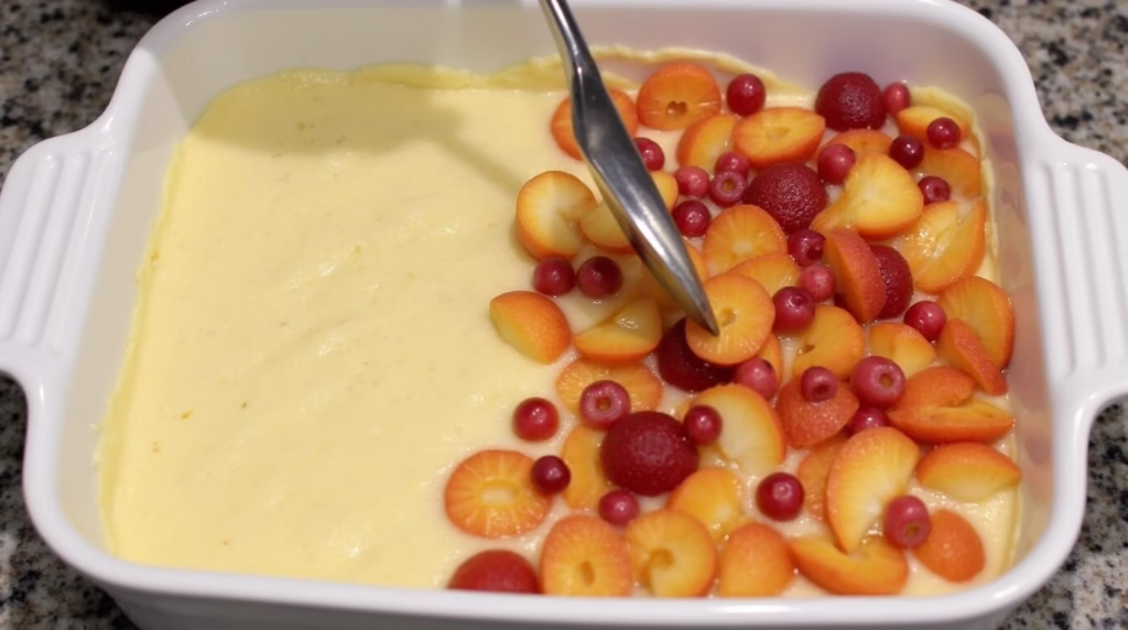Batter with fruit filling layered on top in a baking dish.