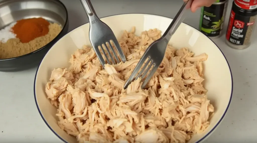 Shredding cooked chicken for Chicken Alfredo Lasagna.